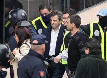 Ginés Jiménez, con chaqueta negra, es trasladado por agentes de paisano a la sede de la Policía Local de Coslada el pasado 8 de mayo.