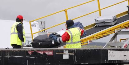 Operarios de WSF cargan maletas en un avión en Madrid-Barajas.