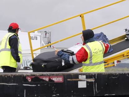 Operarios de WSF cargan maletas en un avión en Madrid-Barajas.