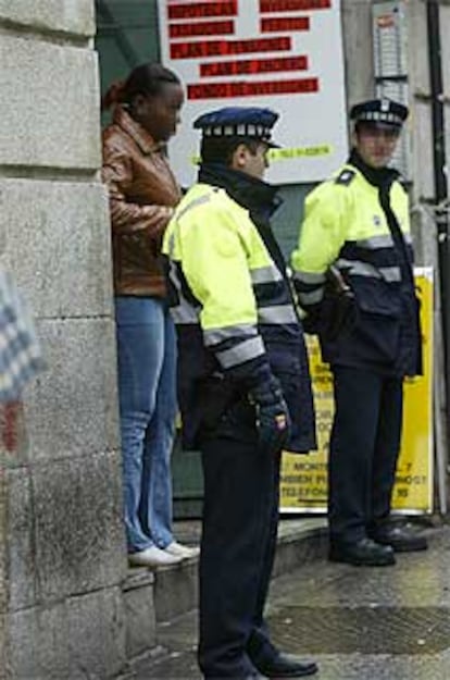 Dos policías vigilan en la Calle de la Montera. Detrás, una mujer ejerce la prostitución.