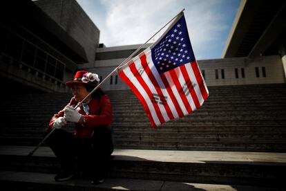 Una manifestante porta las banderas nacionales de los Estados Unidos y Corea del Sur durante una protesta frente a la embajada de EE UU en Seúl.