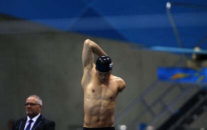 El nadador chino Wei Yanpeng calienta antes de su carrera de 100m mariposa