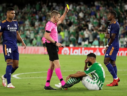 El árbitro Hernández Hernández enseña tarjeta amarilla al bético Nabil Fekir por simular un penalti ante el Madrid.