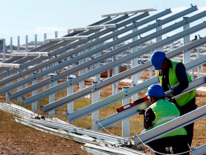 Dos obreros trabajan en la instalación de una planta fotovoltaica de Iberdrola.