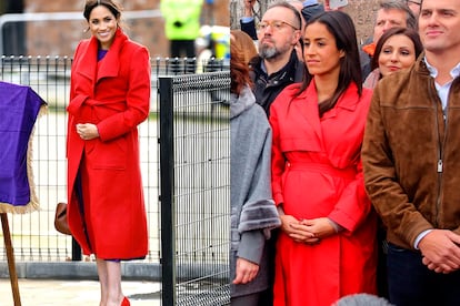 Meghan markle con abrigo rojo anudado y Villacís, en el acto de Colón, con uno más relajado pero similar en patronaje.