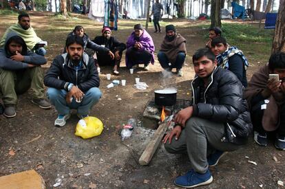 Un grupo de migrantes cocina en la ladera junto al antiguo albergue en Bihac.