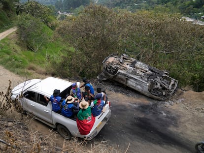 Integrantes de la Guardia Indígena pasan frente a un auto atacado por el EMC en Toribio (Cauca), en marzo.