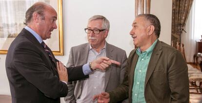 El ministro de Economía, Luis de Guindos (a la izquierda), conversa con los secretarios generales de CC OO, Ignacio Fernández Toxo (en el centro), y de UGT, Pepe Álvarez