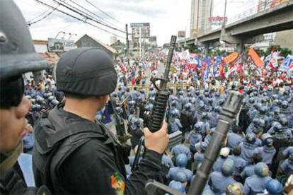 Policías antidisturbios frenan la marcha de los manifestantes en el barrio financiero de Manila.