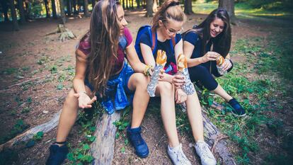 Un grupo de chicas comen durante una ruta de senderismo.