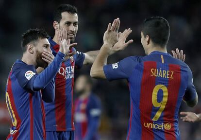 El delantero argentino del Barcelona, Leo Messi (izquierda), celebra con su compañero Sergi Busquets (centro), y el delantero uruguayo Luis Suárez (d) el primer gol frente al Sporting de Gijón.
