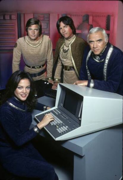 El reparto principal de la serie de 1978. Maren Jensen (Athena), Dirk Benedict (Starbuck), Richard Hatch (Apollo) y Lorne Greene (Adama).