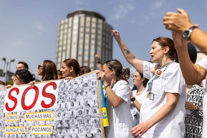 Varias mujeres alzan el puño y sostienen un cartel en el que se lee "SOS", durante la concentración de los trabajadores del Hospital Universitario de La Paz, este martes, por la huelga de 24 horas.