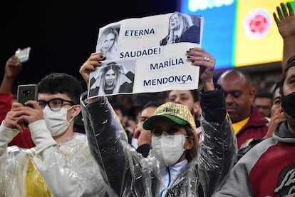 Fã de Marília Mendonça levanta cartaz em sua homenagem no jogo entre Brasil e Colômbia, nesta quinta, em São Paulo.