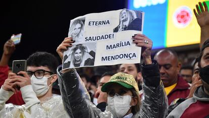 Fã de Marília Mendonça levanta cartaz em sua homenagem no jogo entre Brasil e Colômbia, nesta quinta, em São Paulo.