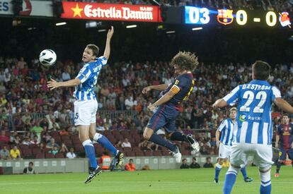 Puyol cabecea a gol ante dos defensores de la Real Sociedad.