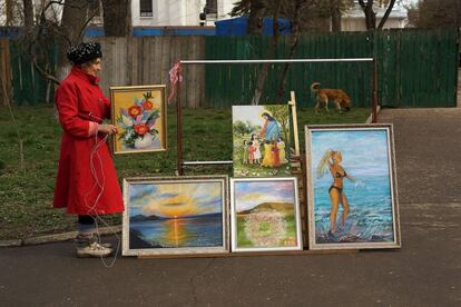 Una artista local muestra sus pinturas en una calle de la ciudad de Simferopol (Ukrania).