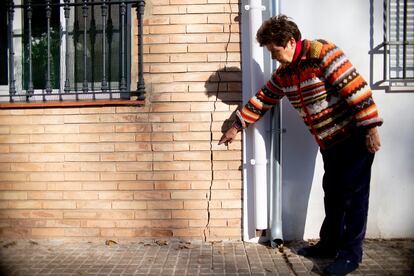 Antoñina Martín señala la grieta que atraviesa la fachada de su casa en Cazalla de la Sierra (Sevilla). 