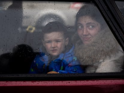 Una madre junto a su hijo miran por la ventana de su coche a la llegada al centro de recepción de refugiados en Zaporizyia.
