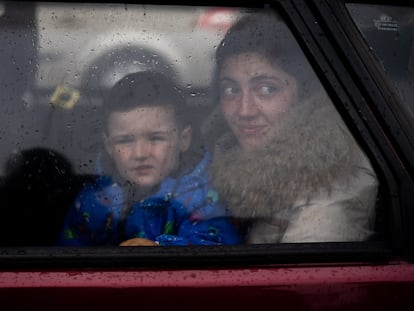 Una madre junto a su hijo miran por la ventana de su coche a su llegada al centro de recepción de refugiados en Zaporizyia.