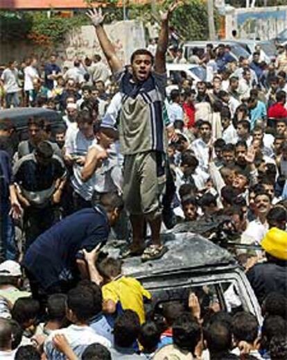 Cientos de palestinos protestan junto al auto destrozado de Rantisi.