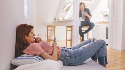 Una pareja utiliza sus teléfonos móviles.