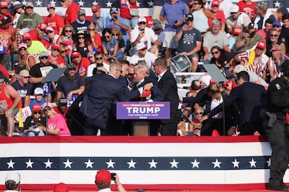 El equipo de seguridad atiende al expresidente de EE UU Donald Trump tras el tiroteo en Butler (Pensilvania).