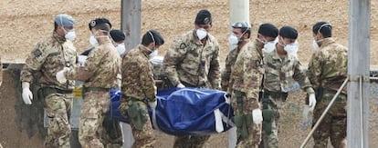 Soldados italianos portan el cadáver de un inmigrante ahogado.