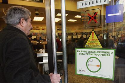 Un hombre entra en un bar madrileño donde está permitido fumar después de que hoy entrara en vigor la ley.