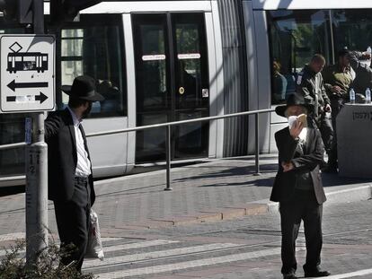 Jud&iacute;os ultraortodoxos ante una parada del tranv&iacute;a de Jerusal&eacute;n.