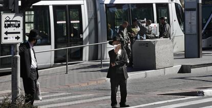 Judíos ultraortodoxos ante una parada del tranvía de Jerusalén.