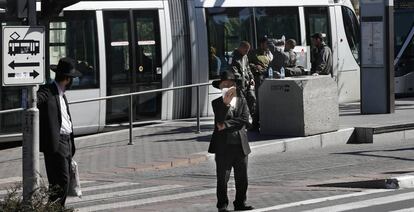 Jud&iacute;os ultraortodoxos ante una parada del tranv&iacute;a de Jerusal&eacute;n.