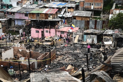 Bomberos y vecinos en el lugar del incendio, este viernes.