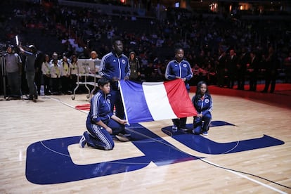Los jugadores de Washington Wizards y Orlando Magic ondean la bandera de Francia antes del comienzo del partido