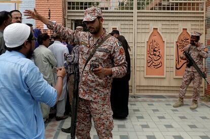 Un ranger indica a un trabajador electoral que acude a recoger el material electoral en Karachi (Pakistán). 