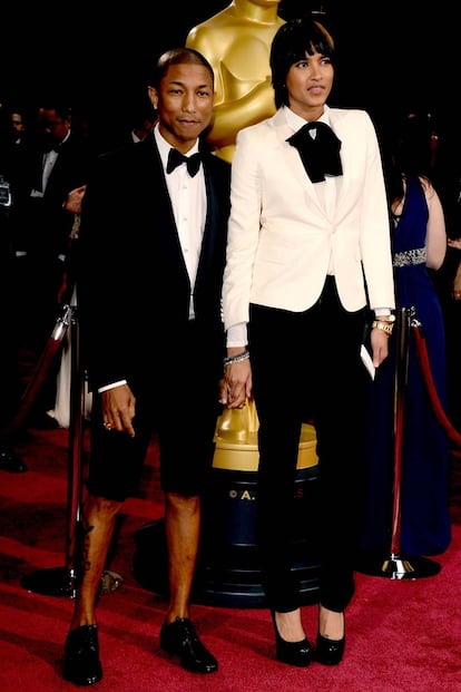 Pharrell, nominado por su canción Happy, sí que sabe innovar en la alfombra roja. Sin su sombrerito de Vivienne Westwood, se pone unas bermudas de Lanvin y acude acompañado de su mujer  Helen Lasichanh.