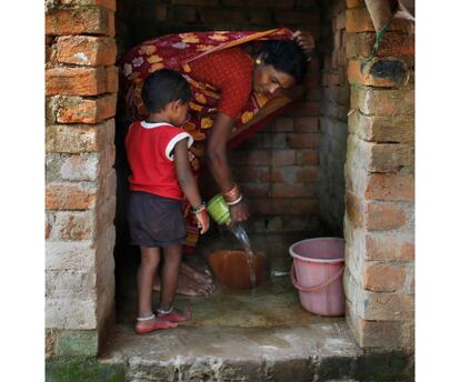 Una mujer limpia el baño que ha utilizado su hijo en la población de Godalwali, en India.