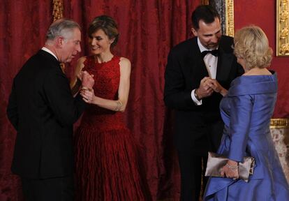 El Príncipe de Gales, Carlos de Inglaterra (i), y su esposa la duquesa de Cornualles, Camilla Parker Bowles (d), saludan respectivamente a la princesa Letizia (2i) y al Príncipe de Asturias, Felipe de Borbón (2d), a su llegada a una cena en el Palacio Real de Madrid en el transcurso de un viaje oficial del heredero del trono del Reino Unido a España, 30 de marzo de 2011.