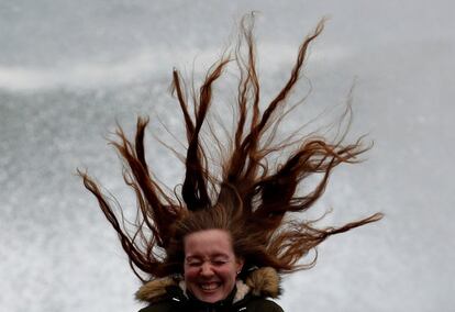 El fuerte viento golpea el pelo de una joven mientras visita el Peine del Viento de San Sebastián (Gipuzkoa).