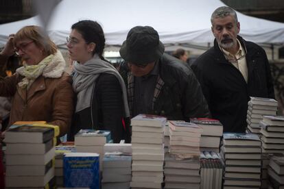 La gent fa un cop d'ull als llibres en una de les parades a la Rambla de Barcelona amb motiu del dia de Sant Jordi.