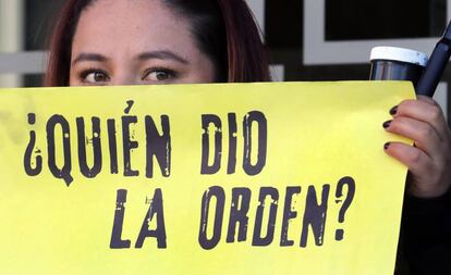 Una mujer sostiene un cartel de protesta frente a la JEP, en Bogotá.