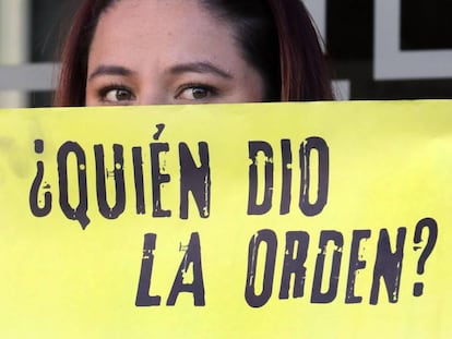 Una mujer sostiene un cartel de protesta frente a la JEP, en Bogotá.