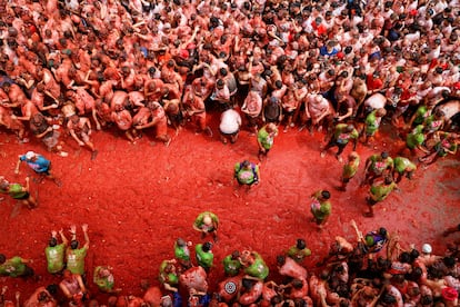 La pulpa de tomate cubre el suelo y a los asistentes tras el paso de los camiones.