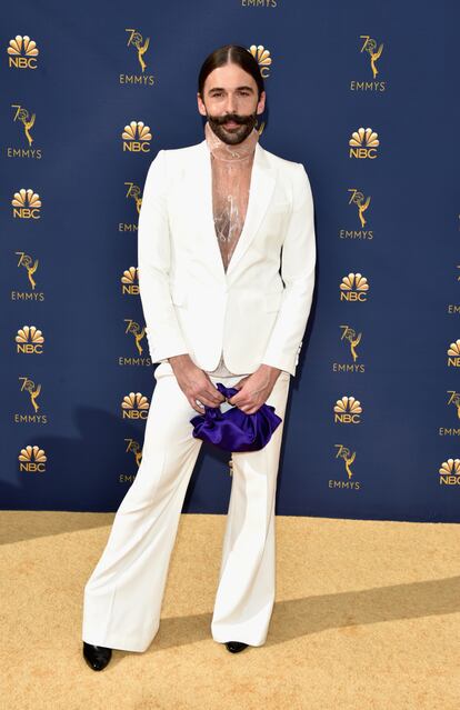 Jonathan Van Ness, el peluquero de Queer Eye, con traje blanco y jersey transparente combinado con bolsito morado de The Row.