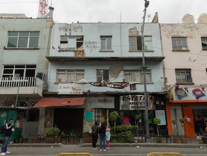 Peatones paran sobre avenida Revolución a observar los daños que causó el microsismo en un edificio, el 12 de diciembre.