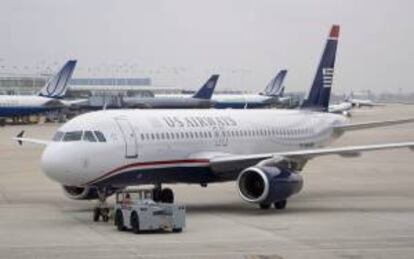 Un avión de US Airways es empujado antes de salir del Aeropuerto Internacional O'Hare en Chicago, Illinois. Una vez que se confirme la fusión, el grupo resultante se convertirá en la mayor aerolínea del mundo. EFE/Archivo