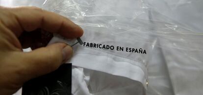 Una trabajadora coloca una etiqueta en una fábrica textil.