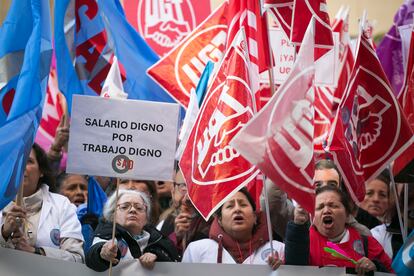 Varias mujeres reclaman un "salario digno por trabajo digno" hoy en la manifestación de cuidadoras a domicilio, frente al Ayuntamiento de Madrid.