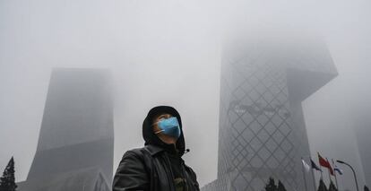 Un hombre camina junto al edicicio de CCTV, en Pekín (China).