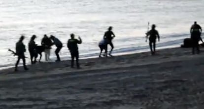 Civil Guard officers returning migrants to Morocco at Tarajal beach.
